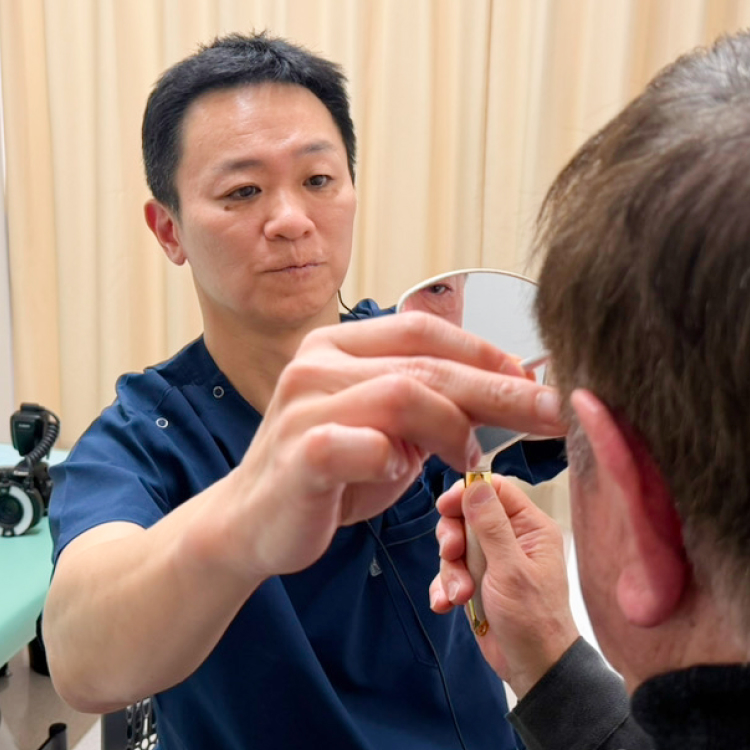 医師が患者に鏡を見せている様子